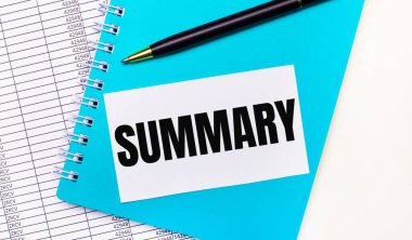 Ofis masasında raporlar var, mavi bir not defteri, siyah bir kalem, ve üzerinde SUMMARY yazan beyaz bir kart. Şık bir iş yeri. İş konsepti