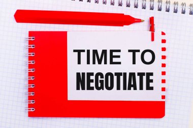 Beyaz bir not defterinde, kırmızı bir kalem, kırmızı bir not defteri ve üzerinde 