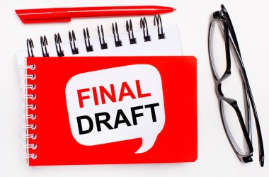 Beyaz arka planda, beyaz ve kırmızı not defterleri, siyah gözlükler, kırmızı bir kalem ve FINAL DRAFT yazılı beyaz bir kart
