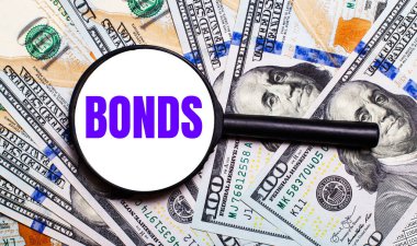 Bir büyüteçin altında dolar banknotları olan bir arka plan. Mali konsept