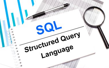 Masada raporlar, şemalar, bir kalem, bir büyüteç ve SQL Yapılandırılmış Sorgu Dili içeren beyaz bir not defteri var. İş konsepti
