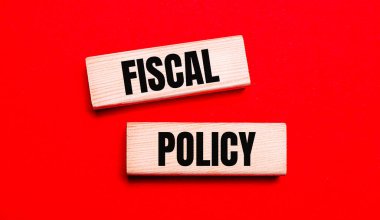 On a bright red background, there are two light wooden blocks with the text FISCAL POLICY clipart