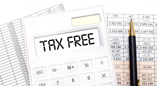 桌面上有报告 记分板上有一个白色计算器和一支钢笔 上面有 Tax免费 的文字 业务概念 — 图库照片