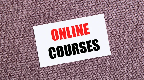 Kahverengi arkaplanda, üzerinde ONLINE COURSES yazan beyaz dikdörtgen bir kart