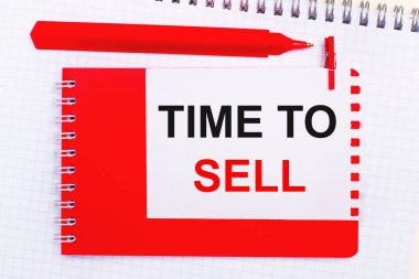 Beyaz bir not defterinde, kırmızı bir kalem, kırmızı bir not defteri ve üzerinde 