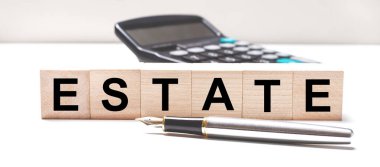 Işık masasında siyah bir hesap makinesi, bir dolmakalem ve üzerinde 