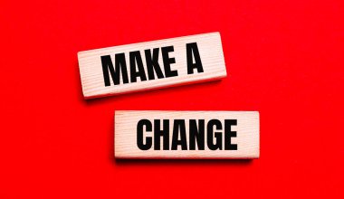 Parlak kırmızı arkaplanda, üzerinde yazı olan iki açık tahta blok var. Değişiklik yap