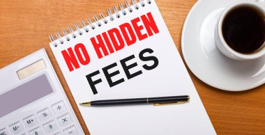 Tahta bir masanın üzerinde beyaz bir hesap makinesi, beyaz bir fincan kahve, bir kalem ve içinde HAYIR Ödemeleri yazılı beyaz bir defter var. İş konsepti