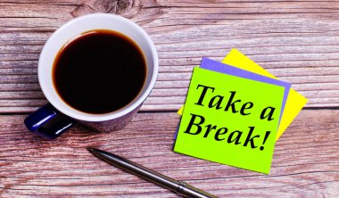 Ahşap bir masanın üzerinde kahve, bir kalem ve üzerinde 