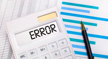 Raporların, mavi grafiklerin, bir kalemin ve ERROR ekranında yazı olan beyaz hesap makinesinin arka planına karşı. İş konsepti