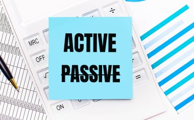 Masaüstünde, üzerinde ACTIVE, bir kalem ve mavi raporlar olan mavi etiketli beyaz bir hesap makinesi var. İş konsepti