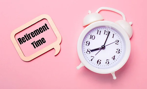 Delicate Pink Background White Alarm Clock Wooden Frame Text Retirement — Stock Photo, Image
