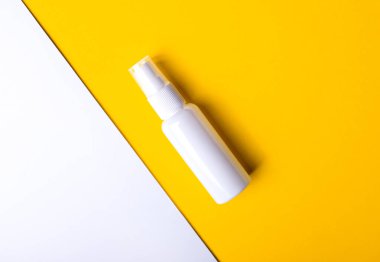 Sarı-beyaz arka planda beyaz bir ilaç şişesi var. Mesaj atabileceği bir yer var. Tıbbi konsept