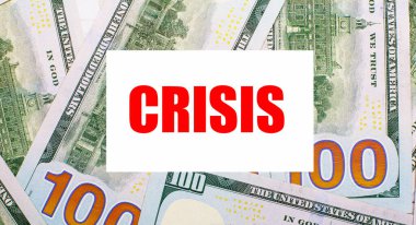Amerikan dolarlarının arka planında CRISIS 'in beyaz kartı var. Mali konsept