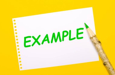 Parlak sarı bir zemin üzerinde, büyük bir tahta kalem ve üzerinde EXAMPLE yazılı beyaz bir kağıt levha