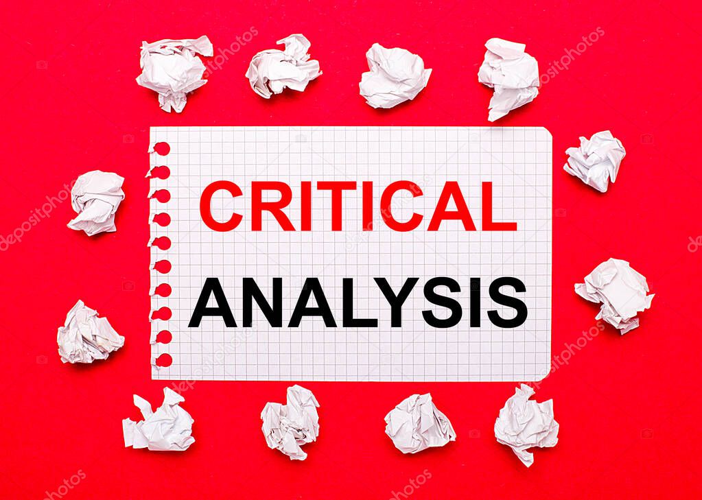 On a bright red background, white crumpled sheets of paper and a sheet of paper with the text CRITICAL ANALYSIS