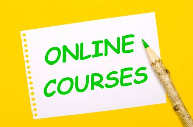 Parlak sarı bir arka planda, büyük bir tahta kalem ve üzerinde ONLINE COURSES yazılı beyaz bir sayfa.