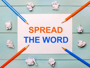 Mavi bir arkaplanda - siyah ve turuncu kalemler, beyaz buruşuk kağıtlar ve beyaz bir kağıt sayfada