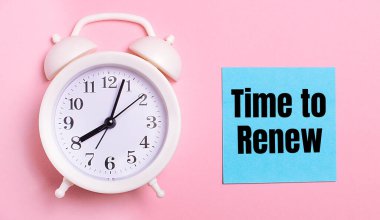 Açık pembe bir arka planda, beyaz bir çalar saat ve üzerinde 