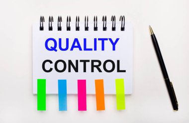 Hafif bir arkaplanda, bir kalem, metin niceliği kontrollü bir defter ve parlak çıkartmalar.