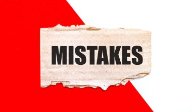 Beyaz ve kırmızı arkaplanda, kahverengi yırtık karton üzerinde MISTAKES metni
