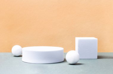Beyaz bir kübün geometrik bileşimi ve hafif arkaplandaki toplar. Paketleme ve kozmetik sunumları için 3D podyum konsepti. Yakın plan, kopyalama alanı