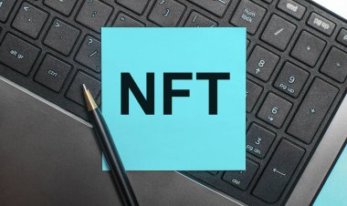 Bilgisayar klavyesinde bir kalem ve içinde NFT Parasız Jeton yazan mavi bir etiket var. Düz yatıyordu.