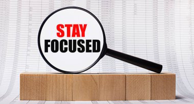 Tahta küplerle ilgili raporların arka planında, üzerinde KALDI yazan bir büyüteç var. İş konsepti.