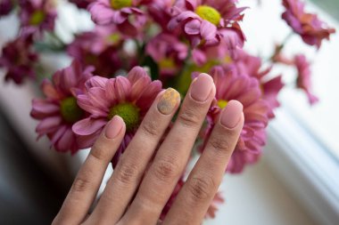 Çivilerin üzerinde mandala ile yumuşak pembe manikür