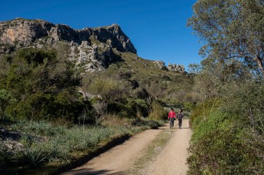 Assarell yolu boyunca yürüyen iki yürüyüşçü, Pollensa, Mallorca, Balearic Adaları, İspanya