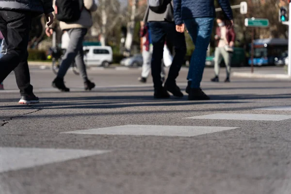 Unrecognizable people walking at the zebra crossing