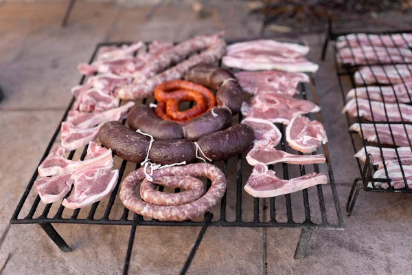 Гриль заполнен различными видами сырого мяса, готового для приготовления на мангале. Концепция обеда на открытом воздухе. — стоковое фото