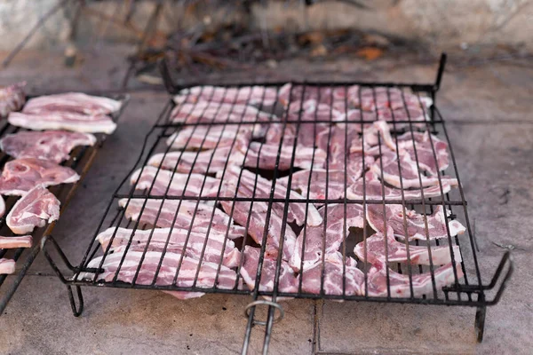 Parrilla llena de carne cruda lista para ser cocinada en la barbacoa. Concepto de fiesta de almuerzo al aire libre. —  Fotos de Stock
