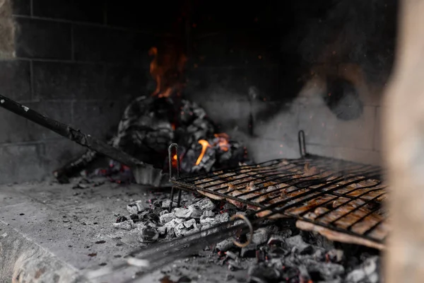 Гриль, полный мяса готовится в барбекю рядом с огнем и углем. Закрыть. — стоковое фото