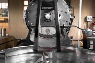 Beyaz kahve çekirdekleri büyük bir kahve makinesinin içinde dinleniyor. Yerel kahve üretimi kavramı