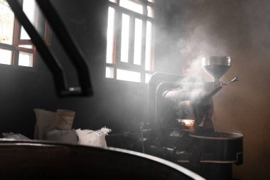 Kahve kızartma makinesi odayı buharla dolduruyor. Yerel kahve üretimi kavramı