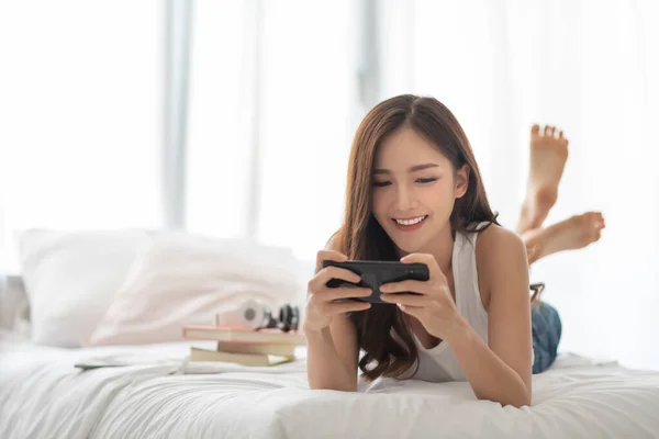 Hermosa Joven Asiática Jugando Juegos Línea Teléfono Inteligente Mientras Está —  Fotos de Stock