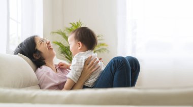 Küçük oğlu birlikte gülen Asyalı bir annenin portresi..