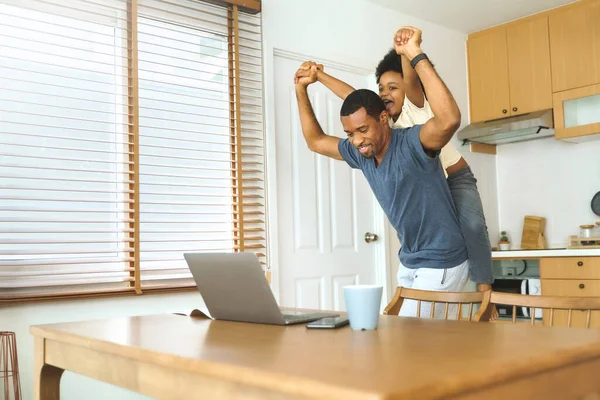 美国黑人父亲在厨房的笔记本电脑上与儿子玩耍 自由职业者在家里干活 Multitasking — 图库照片