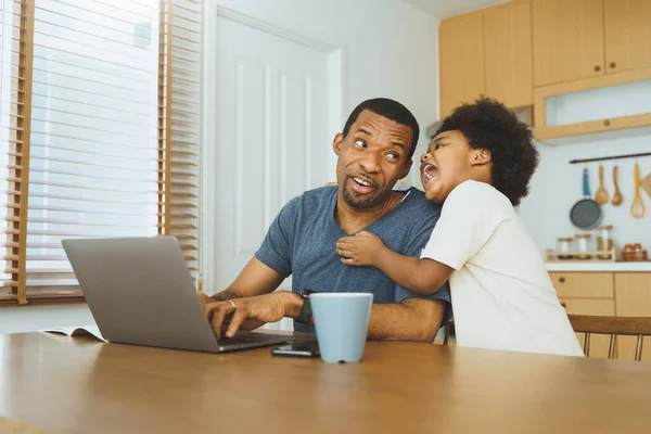 Афроамериканець Який Працює Дому Ноутбуці Весела Дитина Відволікає Його Кухні — стокове фото