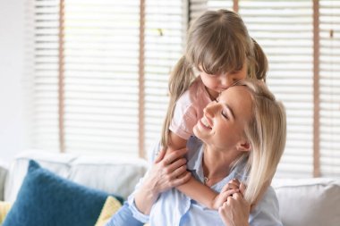 Küçük kız, mutlu anne ve dadıyı kucaklıyor ve öpüyor..