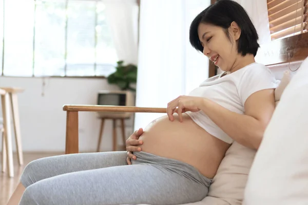 Chinês Japonês Feminino Jogando Sua Barriga Grávida Sentado Sofá Jovem — Fotografia de Stock