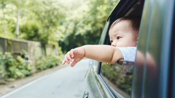 Little Asian boy extend hand outside open window car in holiday, Transportation and travel, Summer vacation