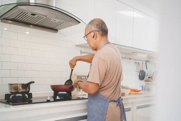 Asian senior man cooking in kitchen, Healthy Food