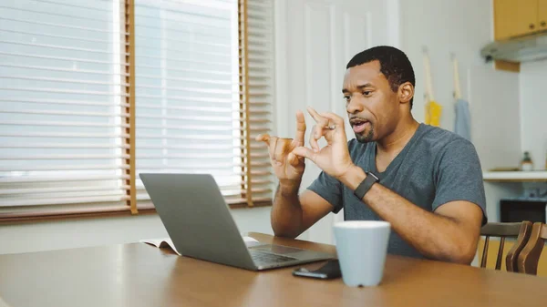 Black African American man having video call online. African Male Freelancer working and meeting with coworker or colleague or team on laptop computer, Work at home