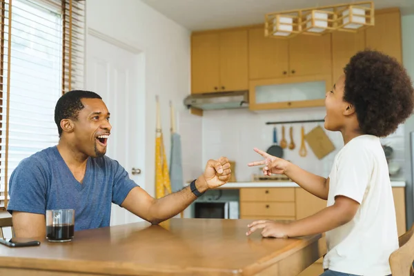 快乐的黑人父亲和小黑人儿子一起在家里玩剪刀纸游戏 — 图库照片