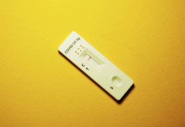 Koleksiyon cihazı Covid-19 antijen test kiti sarı arkaplanda negatif sonuç gösteriyor