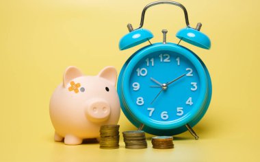 Kumbaranın, çalar saatin ve bozuk paraların resmi. Paranın zaman değeri ve finansal planlama kavramı