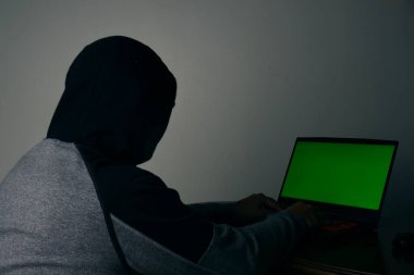Düşük çözünürlüklü bir bilgisayar korsanı fotoğrafı. Yeşil krom anahtar kavrayışı. Hackleme ve siber güvenlik tehdidi kavramı.
