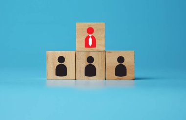 A wooden block with red profile icon symbol as the candidate been chose and leader. Wooden block with black profile icon symbol as not selected candidate. Job hiring and promotion concept.